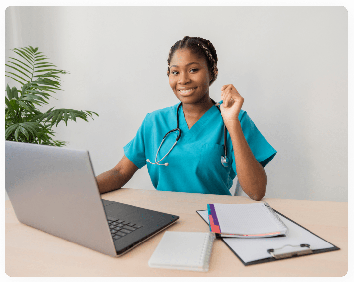Female practicing nurse seated at her desk after successfully completing and passing her HESI A2 Exams.